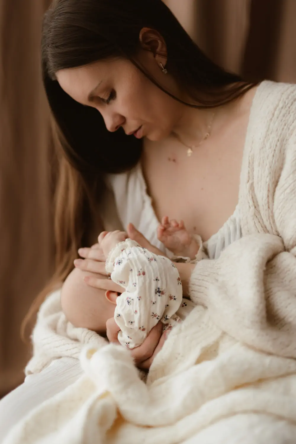 Mama uspáva svoje bábätko pričom mu hladí hlavu rukou počas materského fotenia v ateliéri ZahraPhoto v Nitre