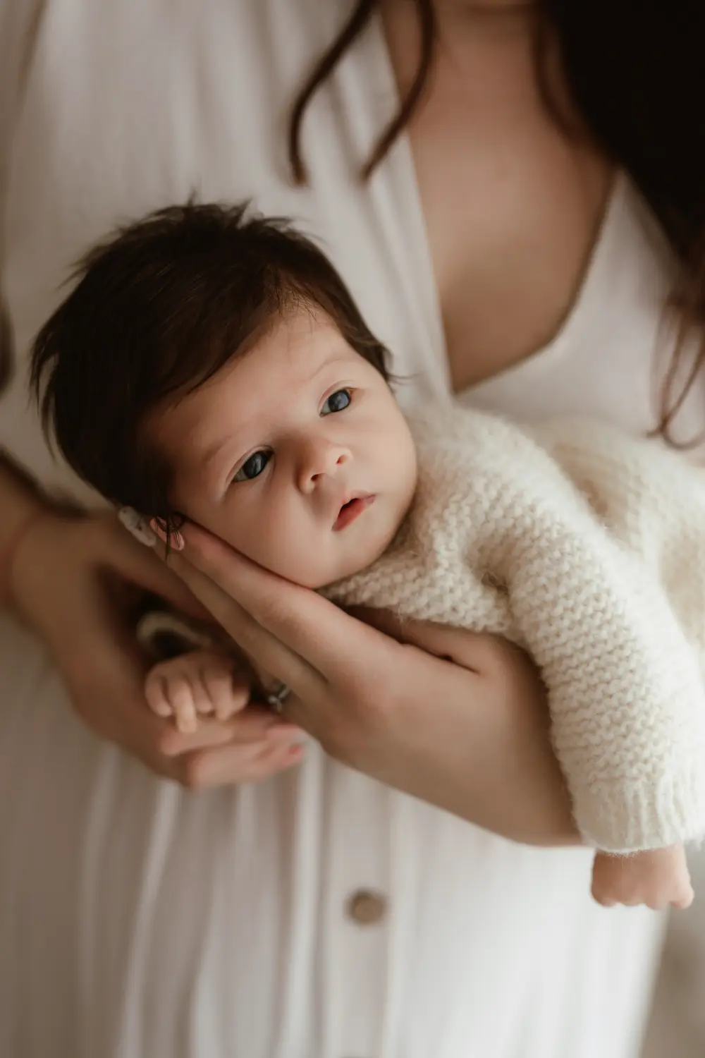 Bdelé mesačné bábätko v dlaniach mami počas newborn fotenia v ateliéri v Nitre