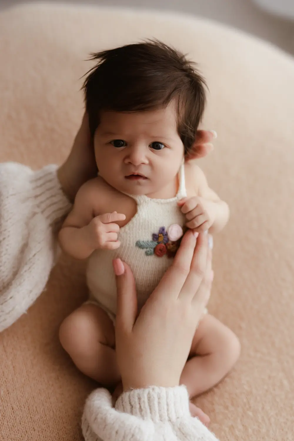 7 týždňové bábätko počas newborn fotenia polohované na bean bagu za pomoci rúk mami počas fotenia bábätiek v Nitre