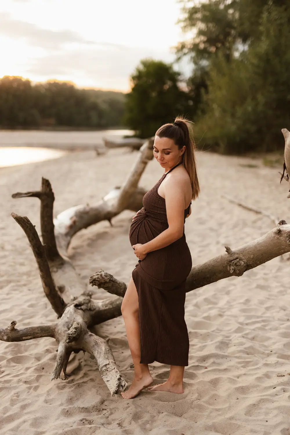 Tehotná žena pózuje počas uvoľneného tehotenského fotenia na pieskovej pláži v Nitre
