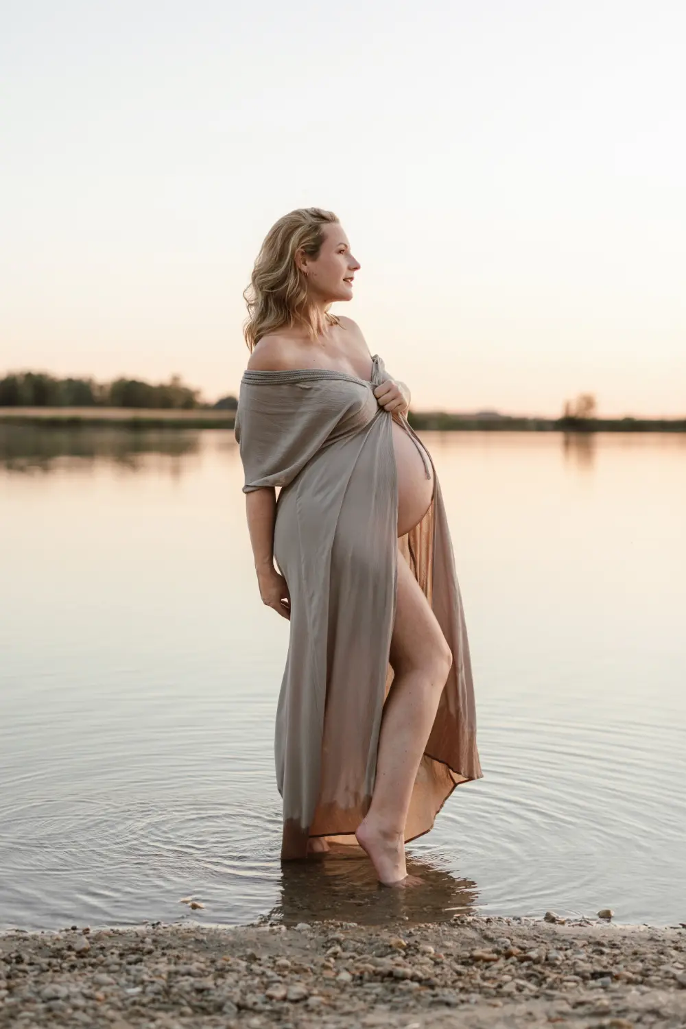 Béžový kaftan z klientskeho šatníka ZahraPhoto počas letného tehotenského fotenia vo vode.